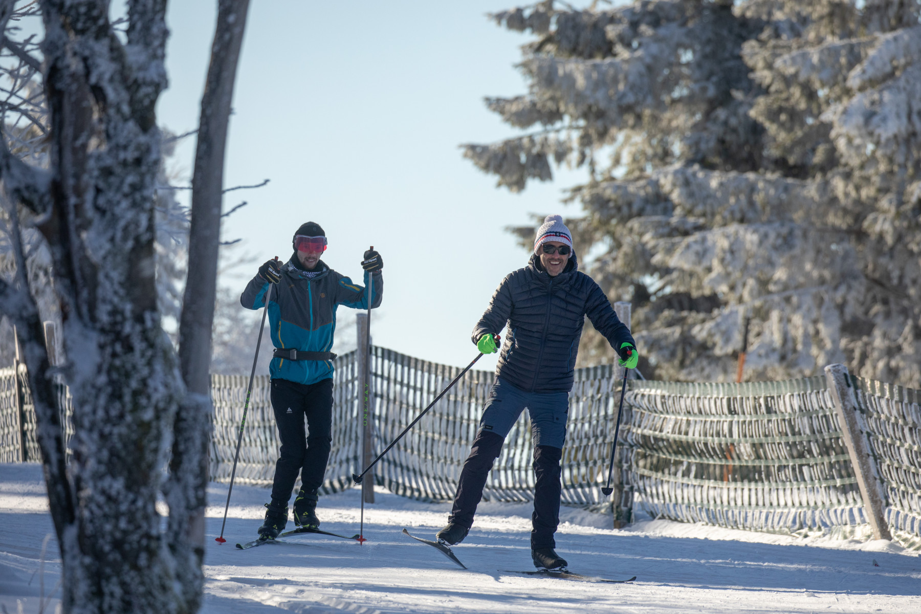 Deux personnes pratiquant du ski nordique sur une piste enneigée au Champ du Feu