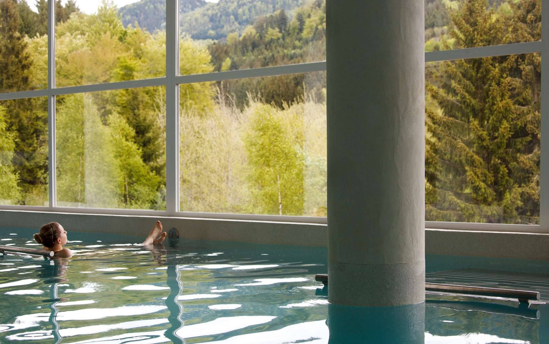 Photo d'une femme se prélassant dans une piscine avec vue sur les paysages extérieurs
